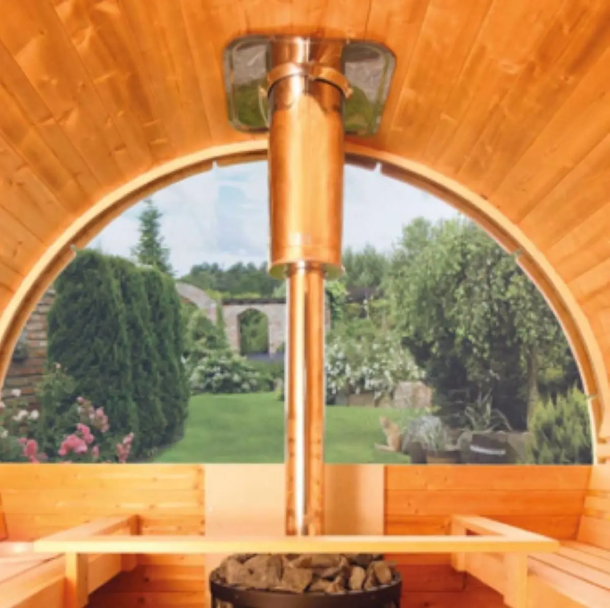 Innenansicht einer Sauna mit einem Kupferofen, Blick auf einen blühenden Garten durch ein großes Rundfenster.