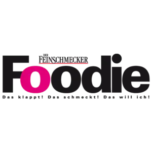 Logo von Der Feinschmecker: Schriftzug Foodie in Schwarz und Pink mit dem Slogan darunter.