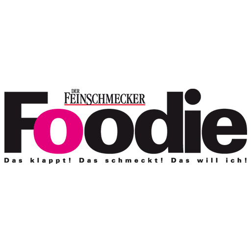 Logo von Der Feinschmecker: Schriftzug Foodie in Schwarz und Pink mit dem Slogan darunter.